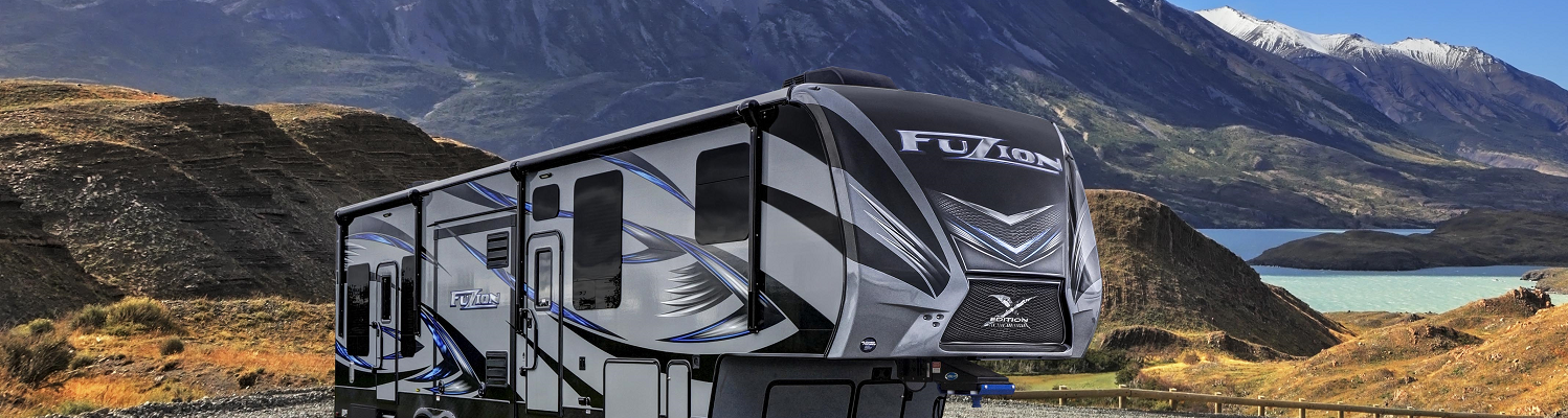 A Heartland RV being displayed in front of a mountain range. 
